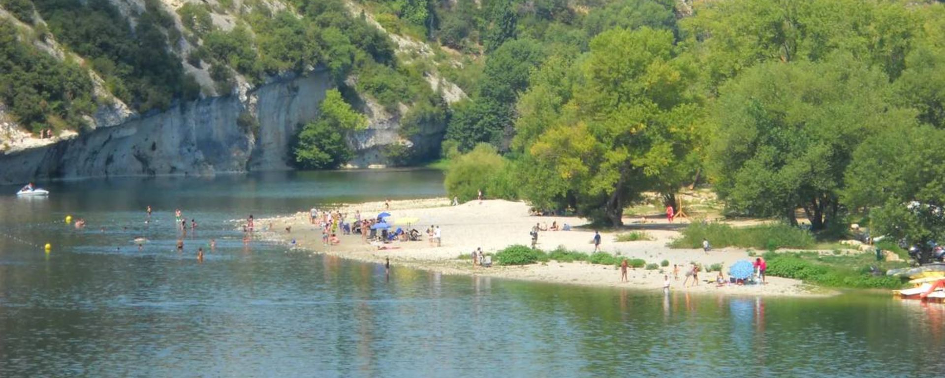 The beach at Saint-Martin in Ardèche with the gorges and the village